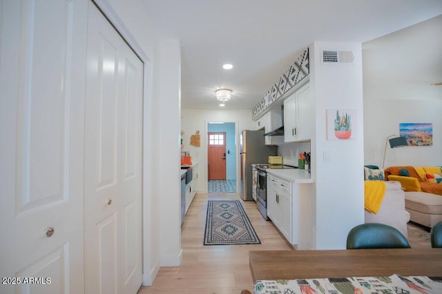 kitchen featuring light hardwood / wood-style floors, white cabinetry, and appliances with stainless steel finishes