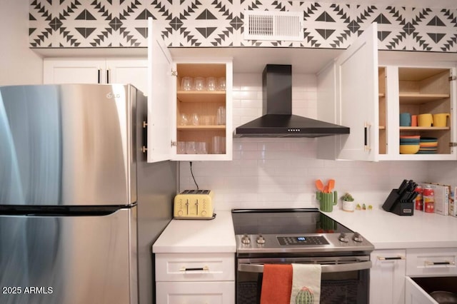 kitchen with white cabinetry, appliances with stainless steel finishes, wall chimney exhaust hood, and tasteful backsplash