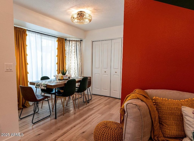 dining area featuring light hardwood / wood-style floors and a textured ceiling