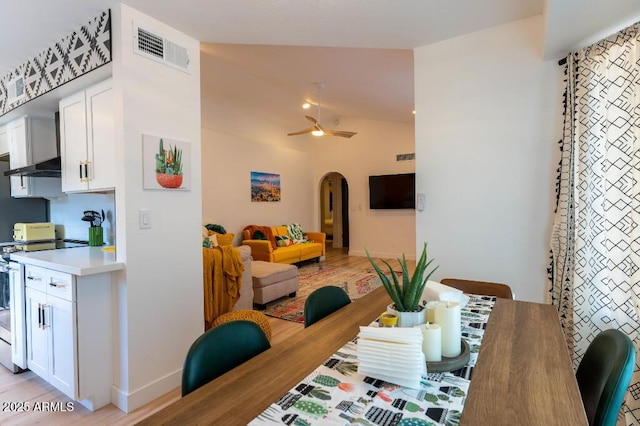 dining room featuring ceiling fan, light hardwood / wood-style flooring, and vaulted ceiling