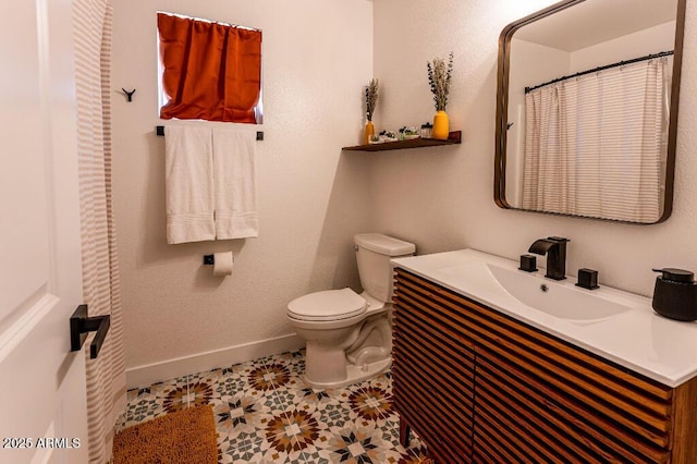 bathroom featuring toilet, vanity, and tile patterned flooring