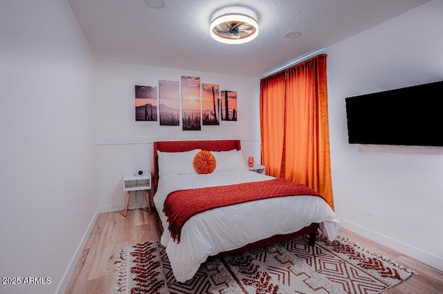 bedroom with hardwood / wood-style floors and a textured ceiling