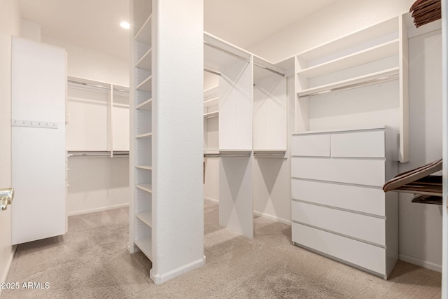 walk in closet featuring light carpet