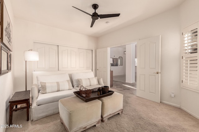 bedroom with ceiling fan, light carpet, and a closet