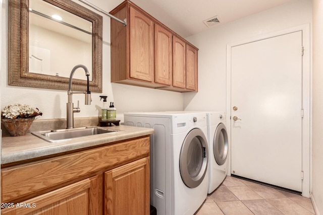 laundry area with light tile patterned flooring, cabinets, sink, and washing machine and dryer