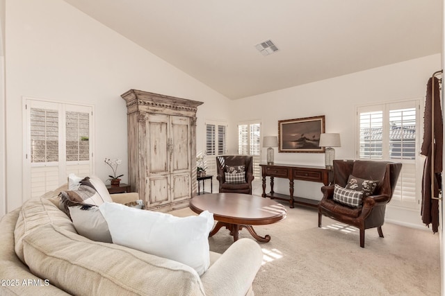 living area featuring light carpet and high vaulted ceiling