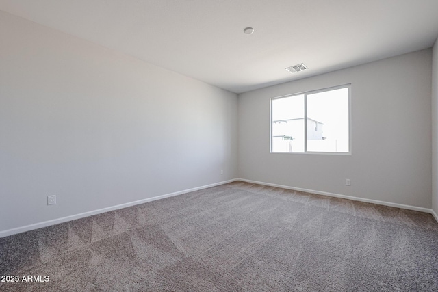 carpeted empty room featuring baseboards and visible vents