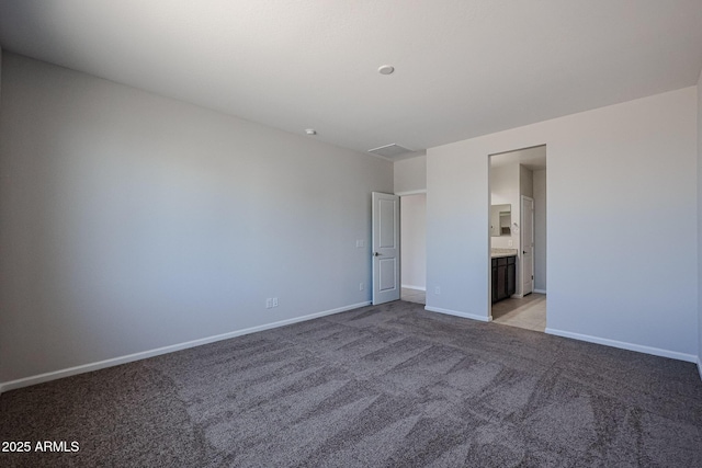 unfurnished bedroom with baseboards, connected bathroom, and light carpet