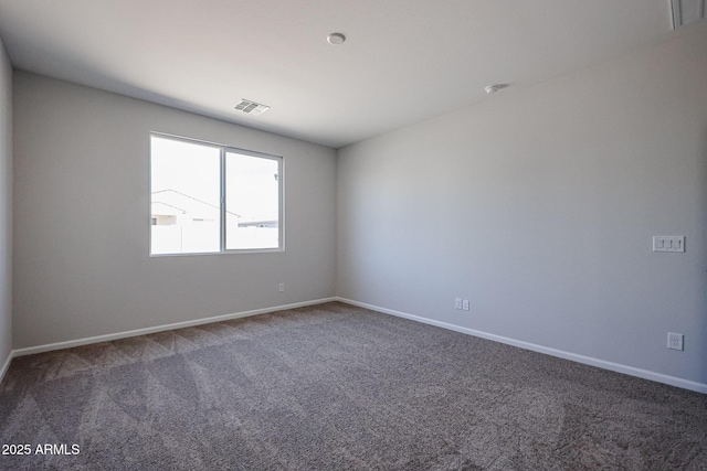 carpeted spare room featuring baseboards and visible vents