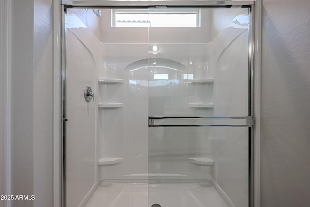 full bath with a textured wall and a stall shower