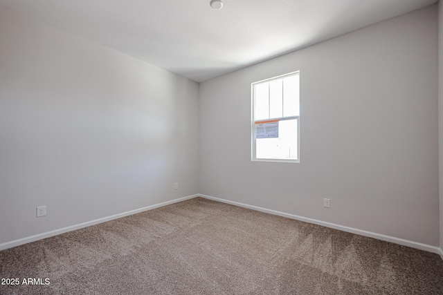 carpeted spare room featuring baseboards