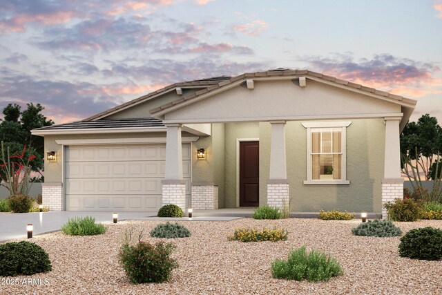 view of front of home featuring a garage, brick siding, stucco siding, and concrete driveway