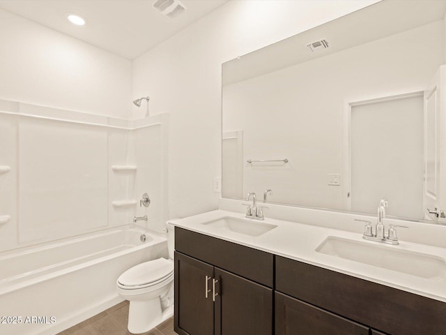 full bathroom with hardwood / wood-style flooring, washtub / shower combination, vanity, and toilet