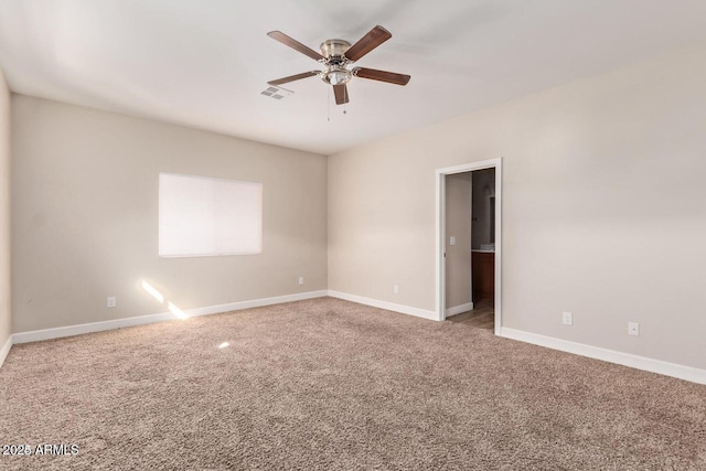 empty room with ceiling fan, carpet, visible vents, and baseboards