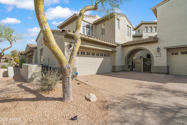 mediterranean / spanish-style house featuring driveway, an attached garage, a tile roof, and stucco siding