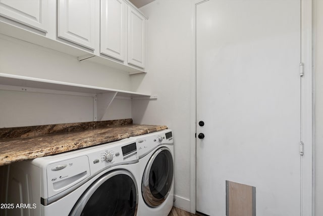 clothes washing area featuring washer and clothes dryer and cabinet space