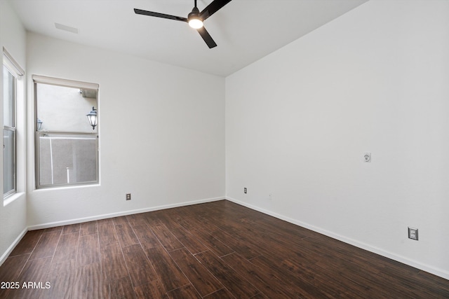 empty room with baseboards, ceiling fan, visible vents, and wood finished floors
