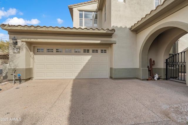 exterior space with a tiled roof, a garage, stucco siding, and driveway