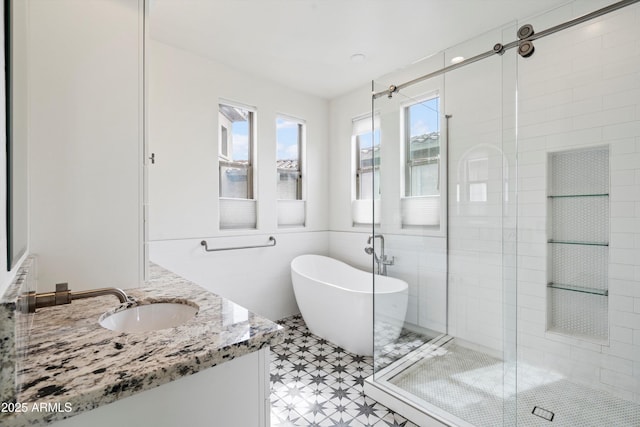 full bath featuring vanity, a freestanding tub, tile patterned floors, and a shower stall