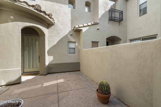 doorway to property featuring a balcony and stucco siding