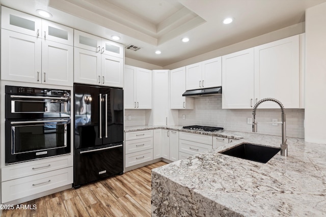 kitchen with visible vents, a sink, white cabinetry, and black appliances
