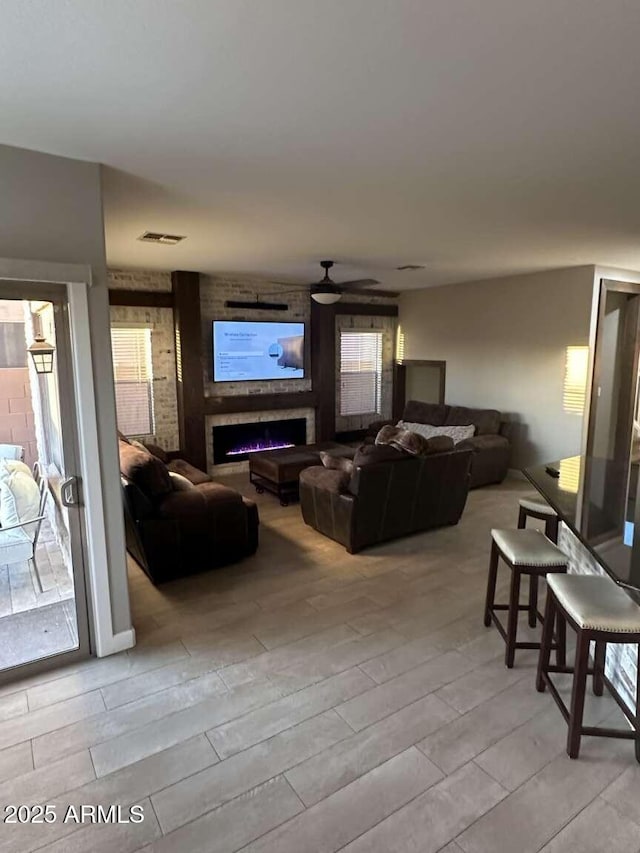 28306 N 25th Dl, Phoenix, AZ 85085 - living area featuring wood tiled floors, ceiling fan, and a brick fireplace