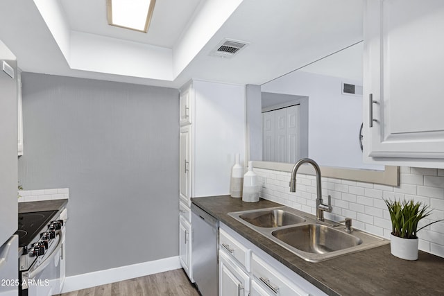 616 S Hardy Dr Unit 203, Tempe, AZ 85281 - kitchen featuring stainless steel appliances, dark countertops, white cabinets, decorative backsplash, and light wood-style floors