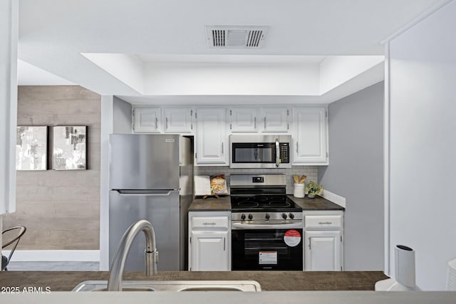 616 S Hardy Dr Unit 203, Tempe, AZ 85281 - kitchen with stainless steel appliances, dark countertops, white cabinets, and tasteful backsplash
