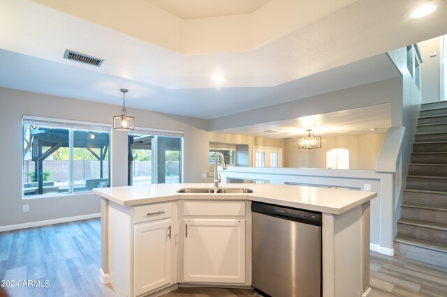 kitchen featuring dishwasher, white cabinets, a center island with sink, and sink