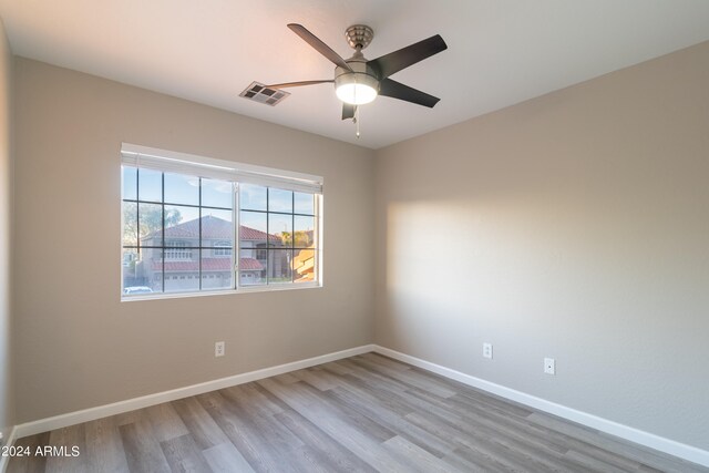 spare room with ceiling fan and light wood-type flooring