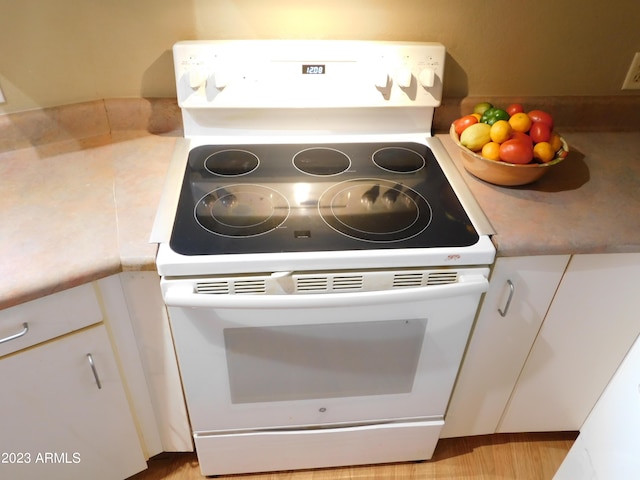 room details with light countertops, white cabinets, and white electric range