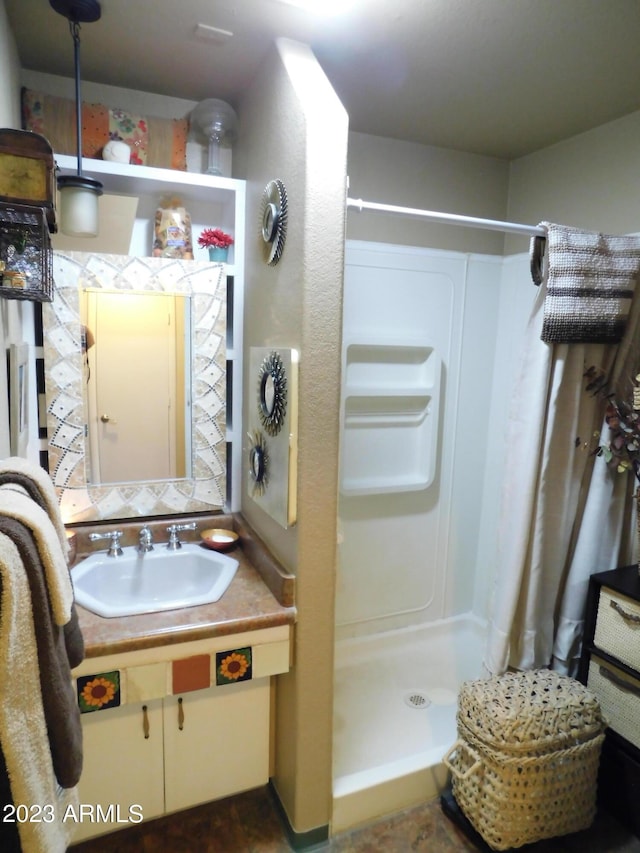 bathroom featuring a shower stall and vanity