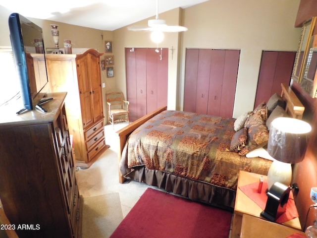 bedroom featuring lofted ceiling, two closets, and carpet floors