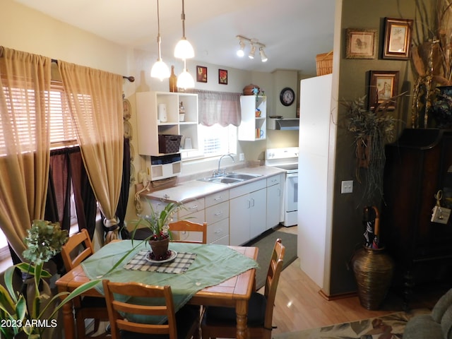 interior space featuring electric stove, a sink, open shelves, white cabinetry, and light countertops