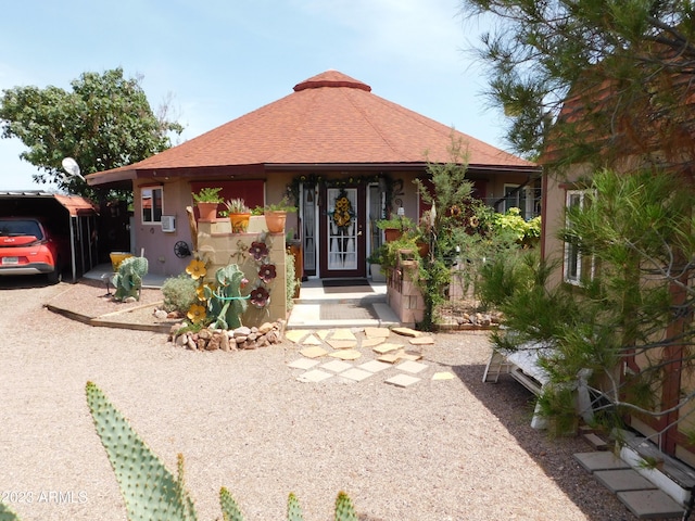 view of front of house featuring stucco siding and roof with shingles