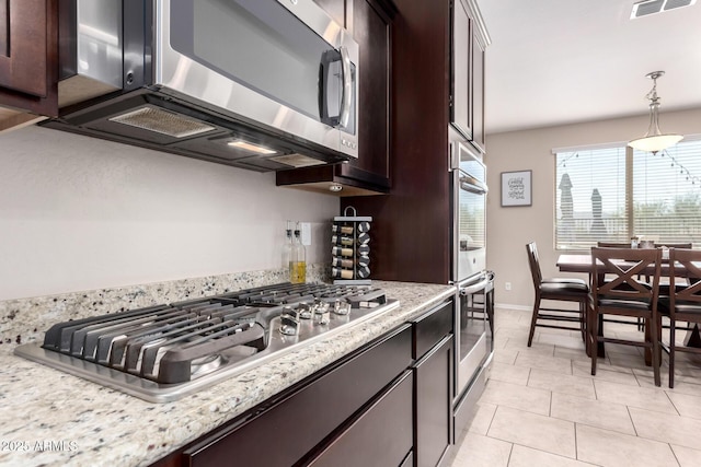 kitchen with stainless steel appliances, dark brown cabinets, and light tile patterned flooring