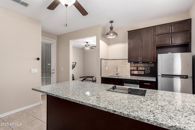 kitchen with visible vents, a sink, stainless steel appliances, dark brown cabinetry, and tasteful backsplash