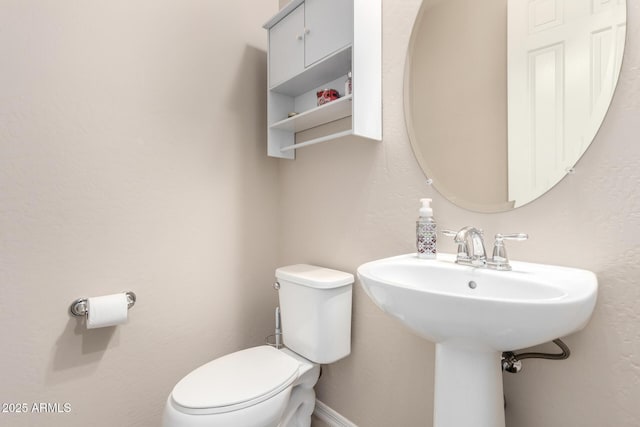 bathroom featuring baseboards and toilet