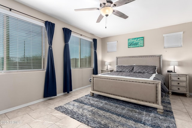 tiled bedroom featuring multiple windows, baseboards, and ceiling fan