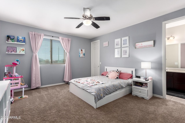 carpeted bedroom featuring ceiling fan, ensuite bath, and baseboards