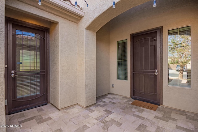 doorway to property featuring stucco siding