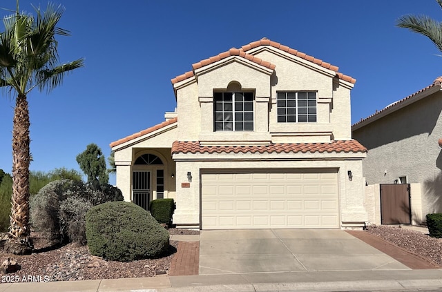 19943 N 77th Ave, Glendale, AZ 85308 - mediterranean / spanish home with concrete driveway, a tile roof, an attached garage, and stucco siding