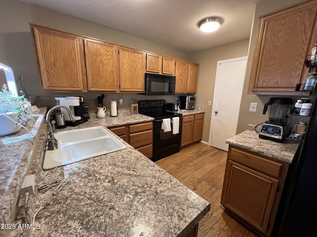 19943 N 77th Ave, Glendale, AZ 85308 - kitchen featuring black appliances, light wood finished floors, and light countertops