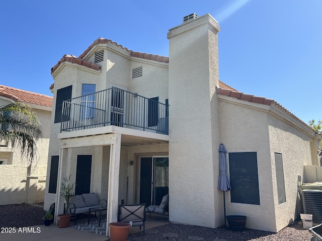 19943 N 77th Ave, Glendale, AZ 85308 - rear view of property featuring a balcony, stucco siding, a patio, a tile roof, and a chimney