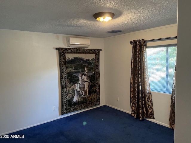 carpeted spare room with a wall mounted air conditioner and a textured ceiling