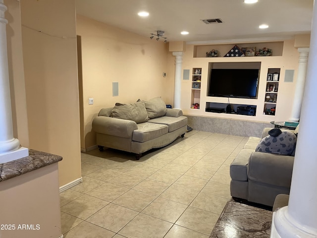 living room with light tile patterned floors, built in features, and ornate columns