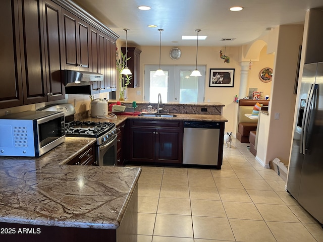 kitchen featuring sink, appliances with stainless steel finishes, dark brown cabinets, decorative light fixtures, and kitchen peninsula