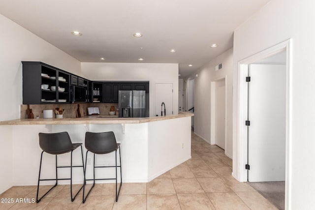 12642 N Mountainside Dr Unit B, Fountain Hills, AZ 85268 - kitchen featuring stainless steel refrigerator with ice dispenser, dark cabinetry, a sink, a breakfast bar, and a peninsula