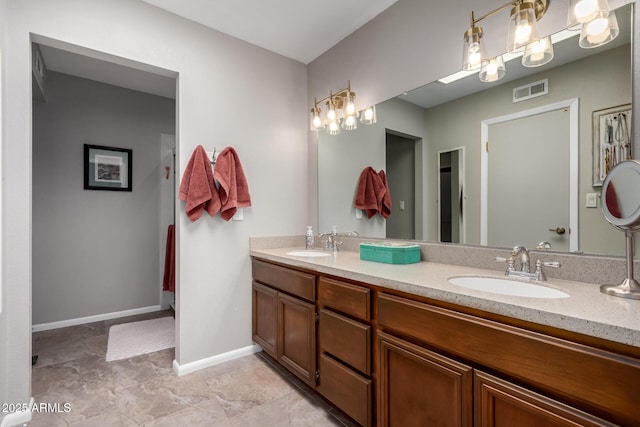 full bath with baseboards, double vanity, a sink, and visible vents