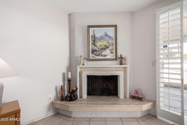 interior space with a high end fireplace, baseboards, and light tile patterned floors